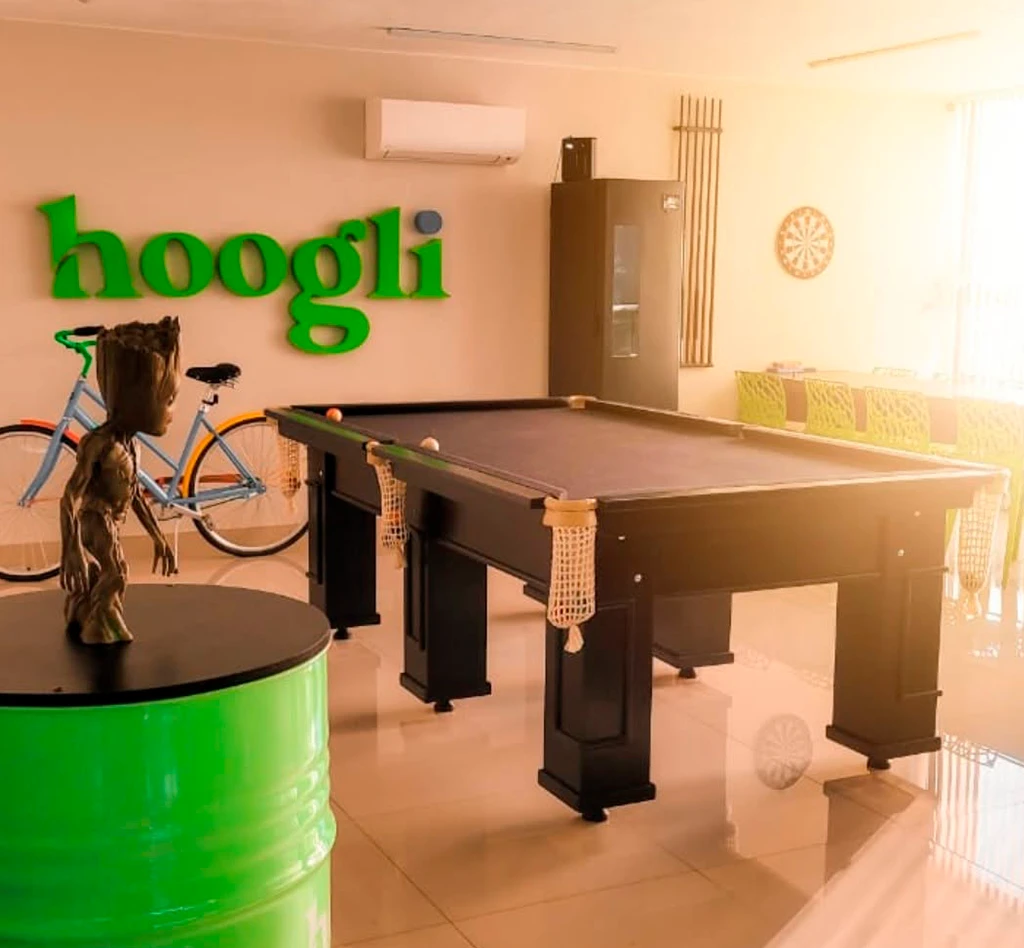 Interior do escritorio da Hoogli com mesa de bilhar e logo verde