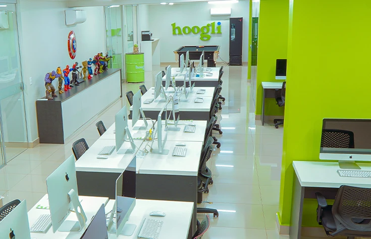 Escritorio da Hoogli com mesas brancas e cadeiras ergonomicas